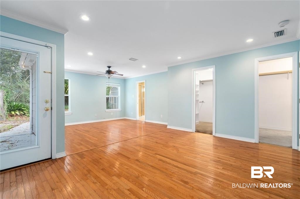 218 Grand Boulevard Mobile, AL 36607 - Photo 12 of 22 Spare room featuring ceiling fan, a wealth of natural light, ornamental molding, and light hardwood / wood-style floors