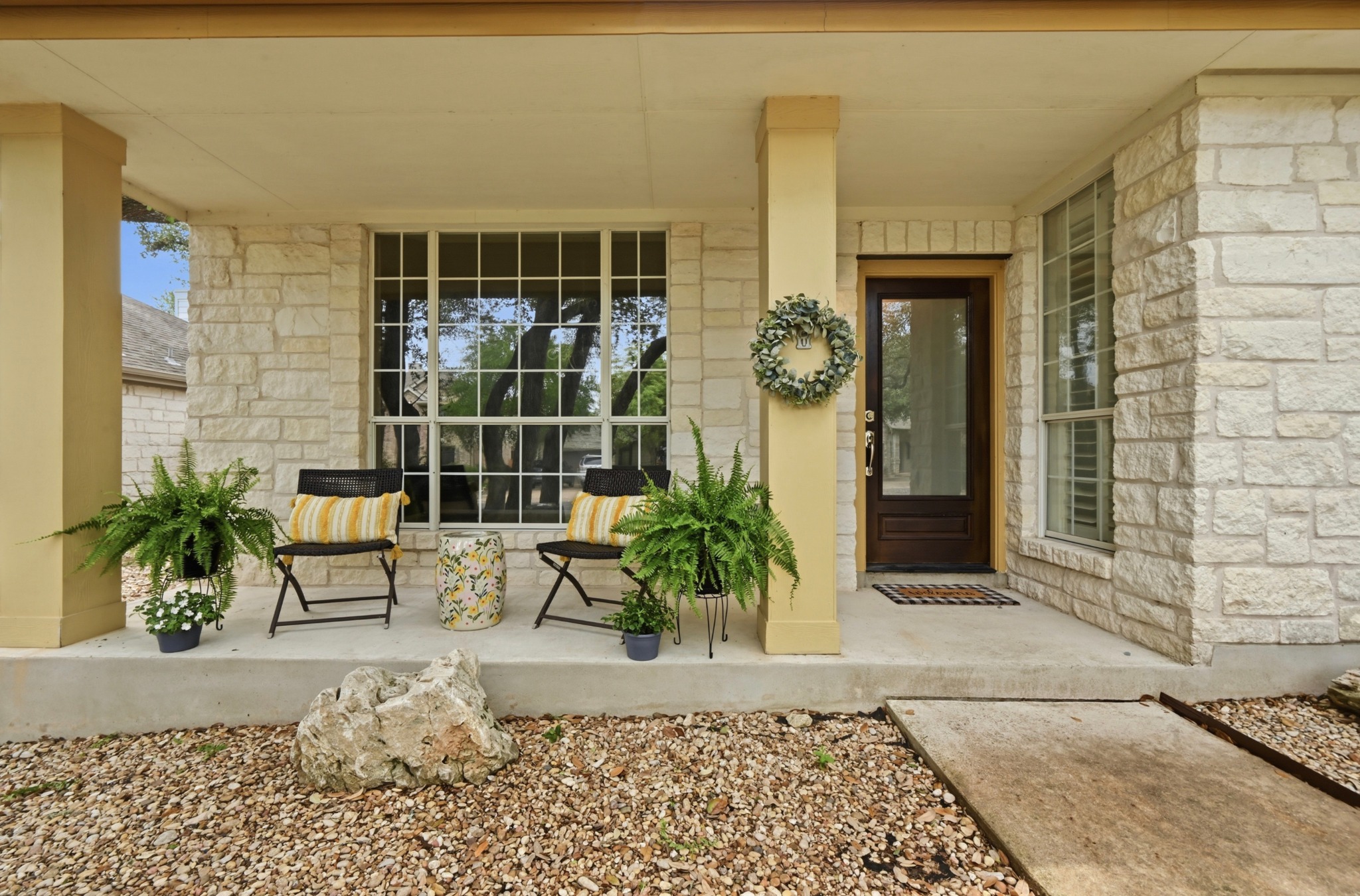 5313 Moon Shadow Drive Austin, TX 78735 - Photo 2 of 30 Stone facade entry featuring a covered porch, dark wood-finish door with glass paneling, and a large multi-pane window