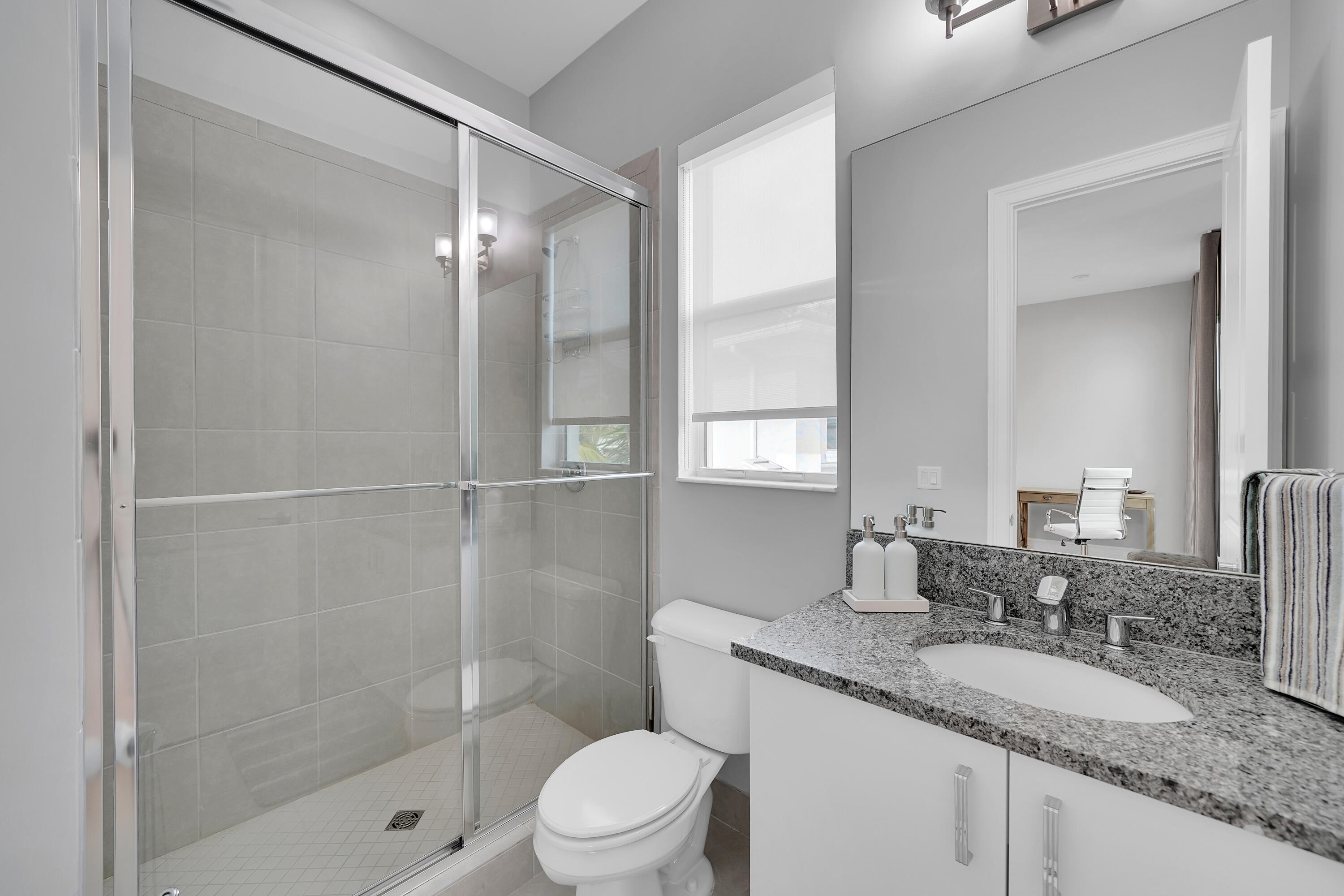 19871 Meadowside Lane Boca Raton, FL 33498 - Photo 56 of 102 a bathroom with a granite countertop sink a mirror and a shower