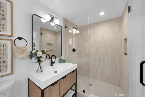 a bathroom with a sink a shower a mirror and a bathtub