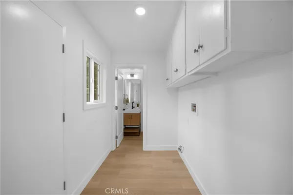 a view of a hallway with bathroom and a sink