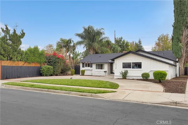 a front view of a house with a yard and trees