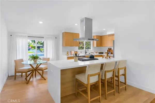 a kitchen with a dining table chairs and sink