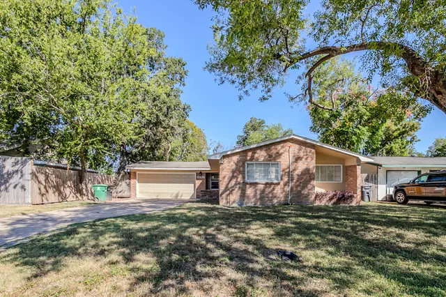 a view of a house with backyard and a tree