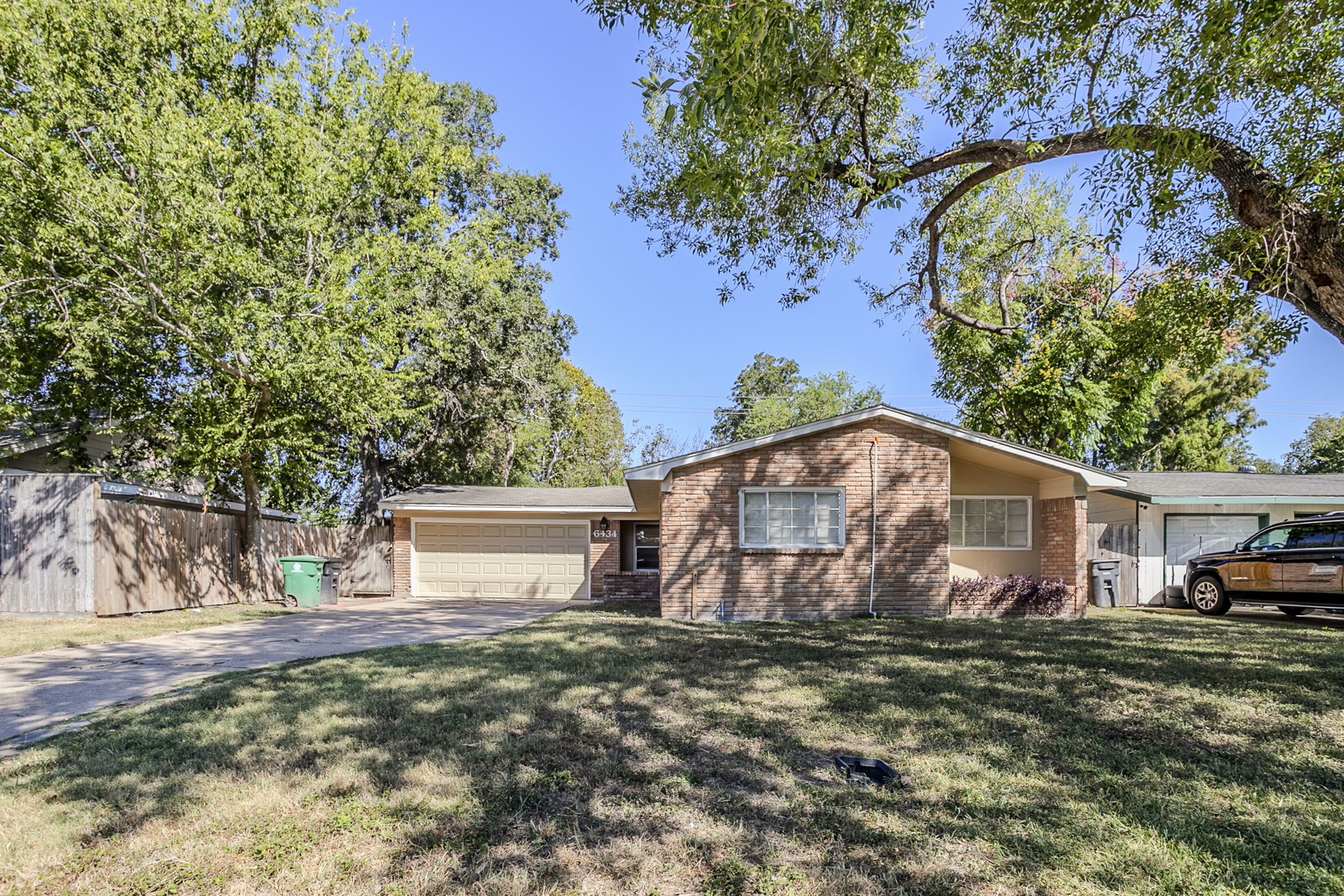 a view of a house with backyard and a tree