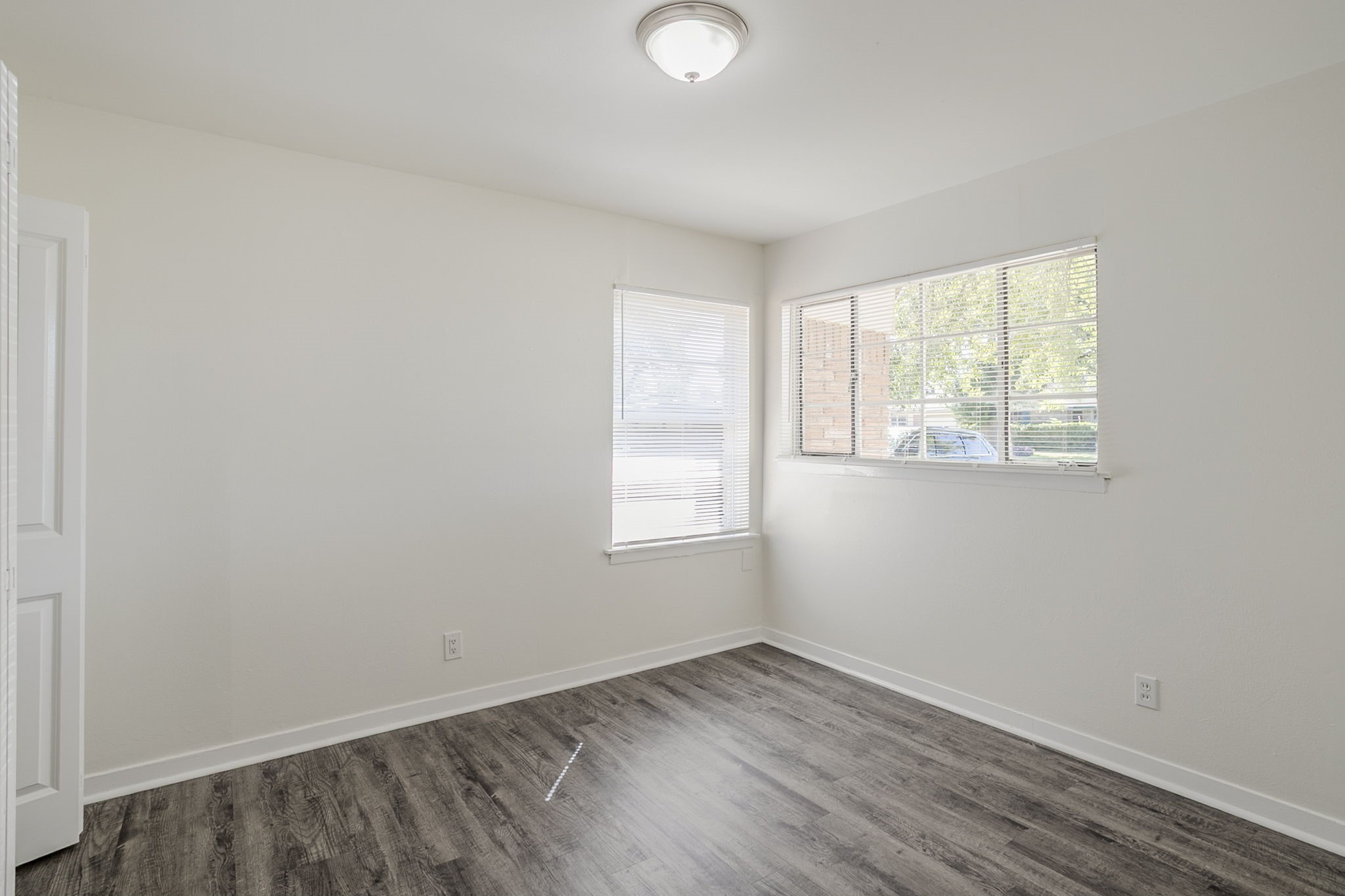6434 Leader Street Houston, TX 77074 - Photo 12 of 46 an empty room with wooden floor and windows