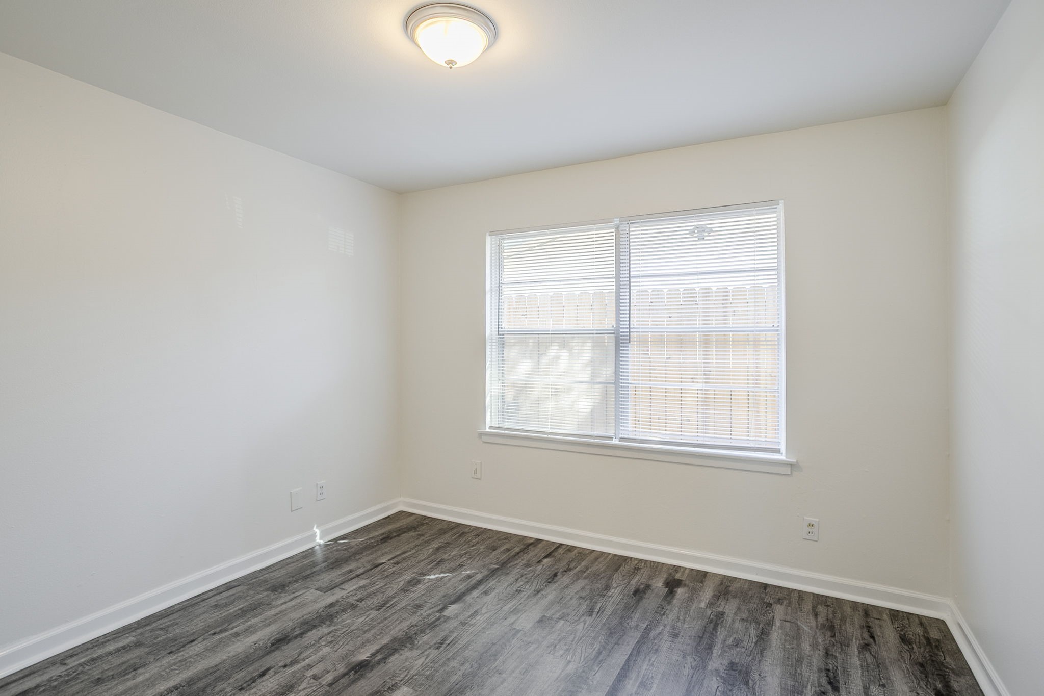 6434 Leader Street Houston, TX 77074 - Photo 14 of 46 an empty room with wooden floor and windows