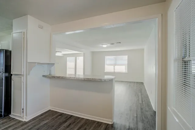 a view of a kitchen with wooden floor and a window