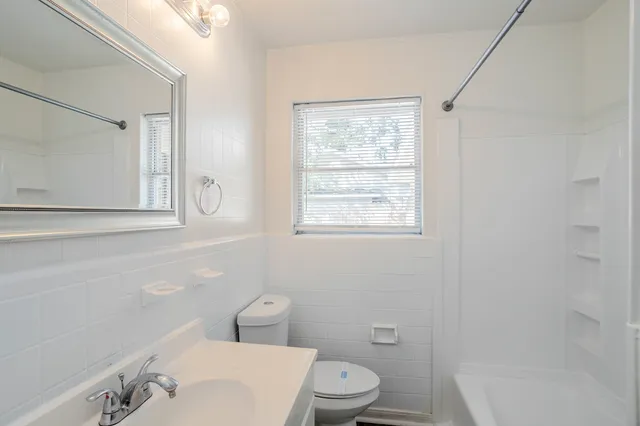 a white toilet sitting next to a bathroom sink