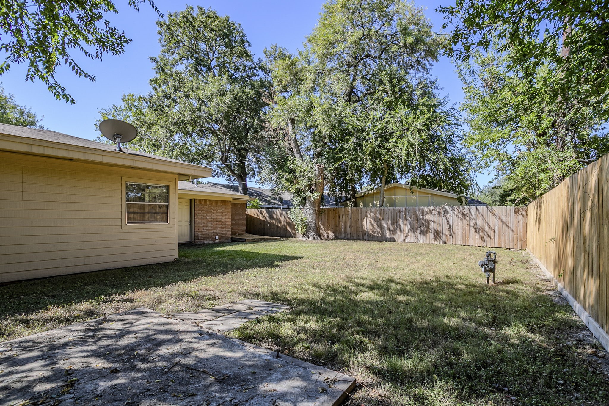 6434 Leader Street Houston, TX 77074 - Photo 44 of 46 a backyard of a house with large trees and wooden fence