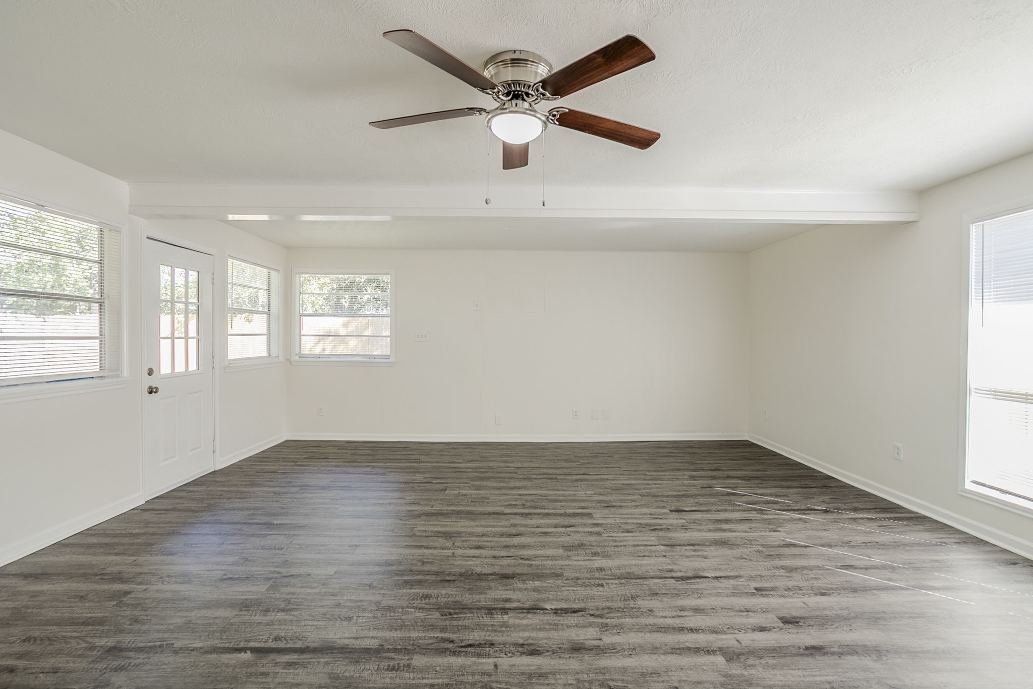 6434 Leader Street Houston, TX 77074 - Photo 8 of 46 an empty room with wooden floor fan and windows