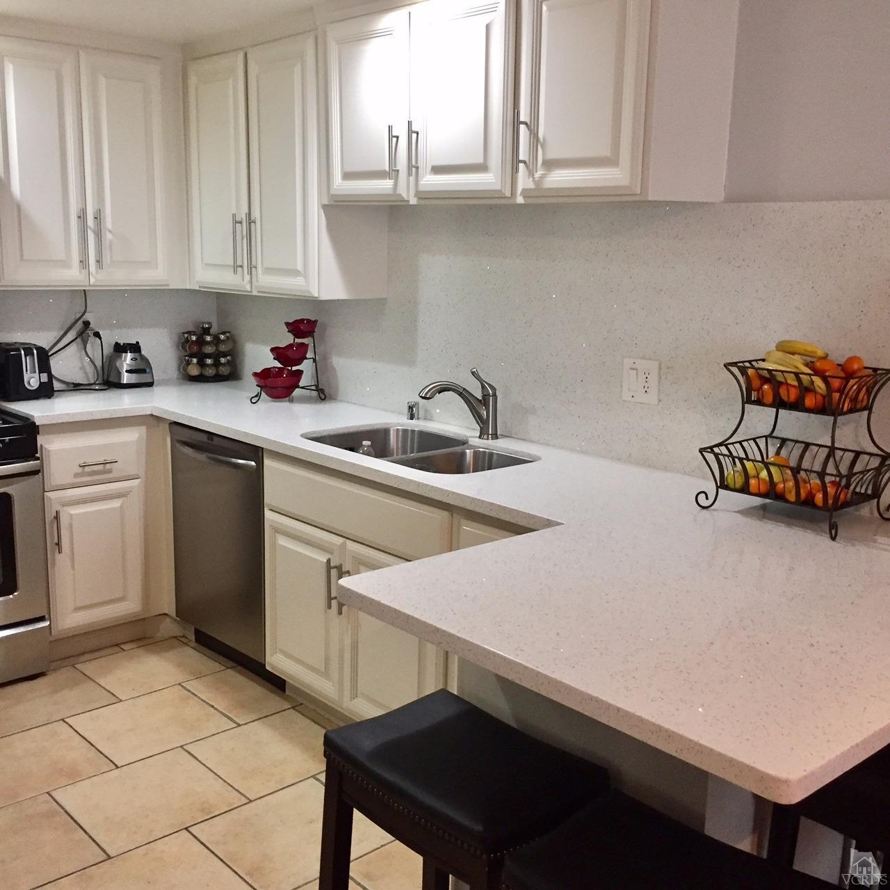 532 Spring Road, Unit 102 Moorpark, CA 93021 - Photo 4 of 10 a kitchen with stainless steel appliances a sink a stove a refrigerator and cabinets