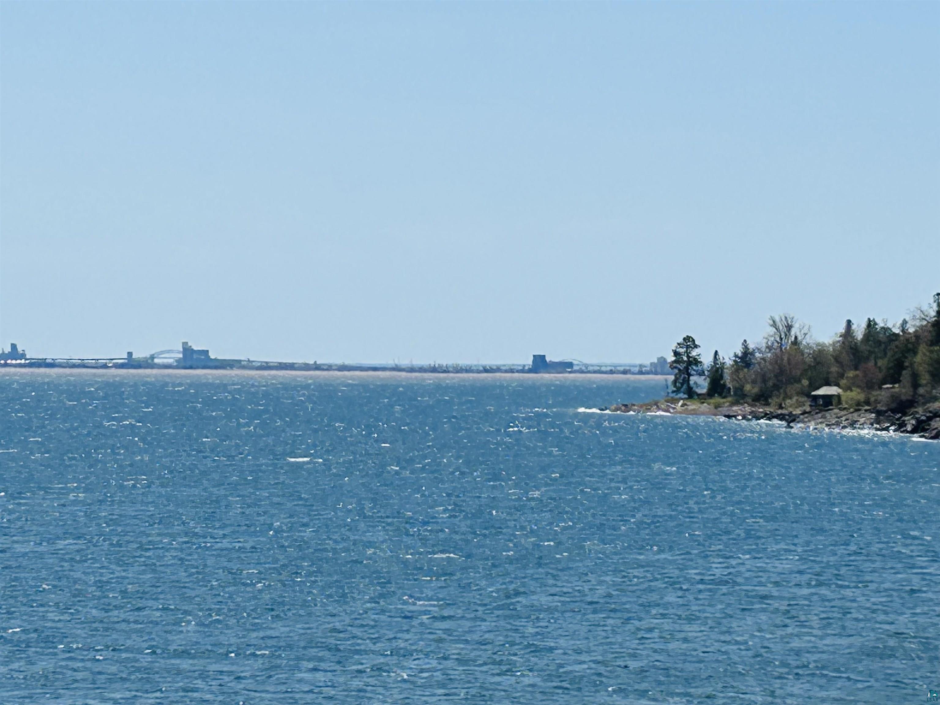 5090 London Road, Unit 1 Duluth, MN 55804 - Photo 47 of 54 Expansive water body with a distant landmass and architectural structures on the horizon