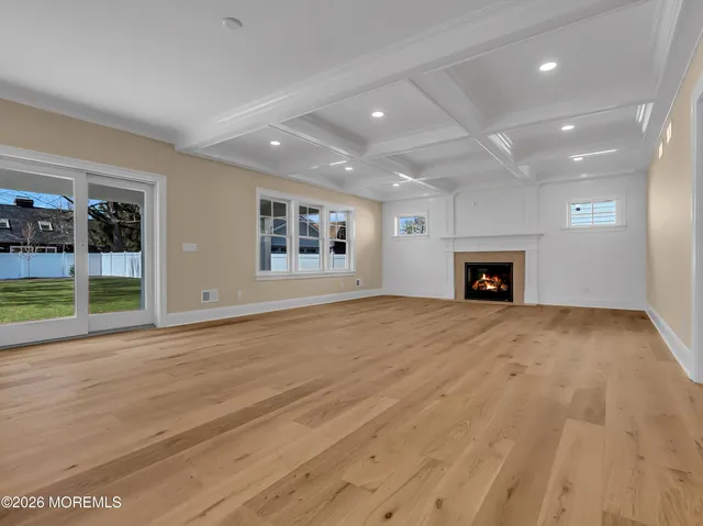 an empty room with floor to ceiling window and fireplace
