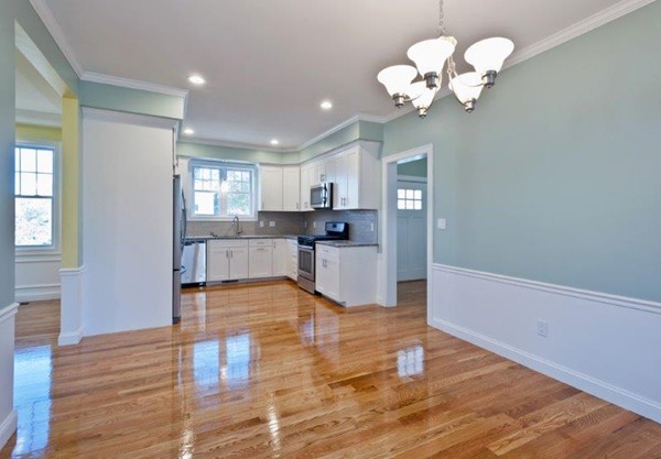 49 Tarbox Street Dedham, MA 02026 - Photo 12 of 30 a view of a kitchen with a sink wooden cabinet and a living room view