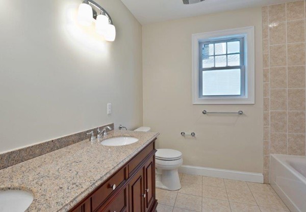 49 Tarbox Street Dedham, MA 02026 - Photo 25 of 30 a bathroom with a granite countertop sink a toilet and bathtub