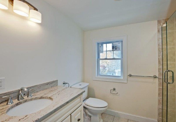 49 Tarbox Street Dedham, MA 02026 - Photo 28 of 30 a bathroom with a granite countertop sink toilet and mirror