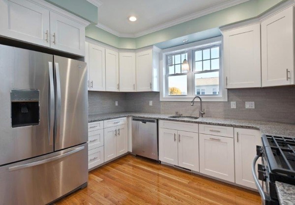 49 Tarbox Street Dedham, MA 02026 - Photo 10 of 30 a kitchen with stainless steel appliances granite countertop a refrigerator sink and cabinets