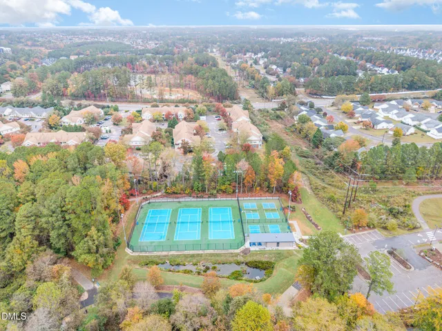 a view of a tennis ground with large trees