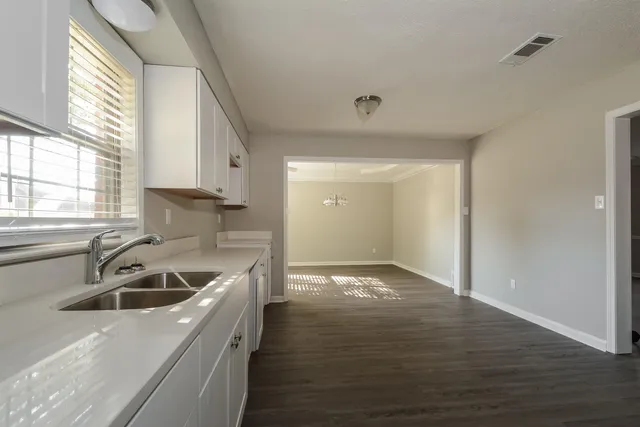 a kitchen with a sink a stove and cabinets