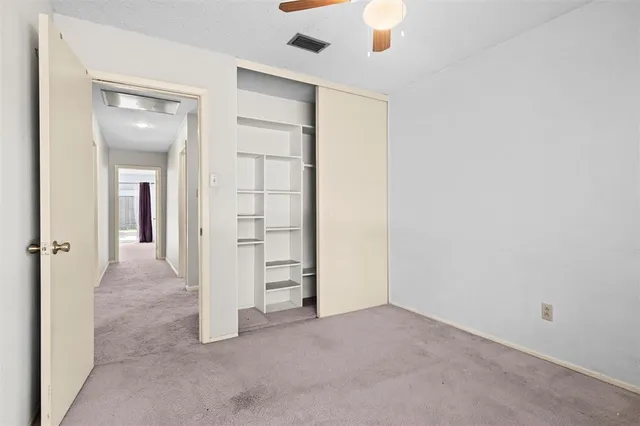 an empty room with closet and windows