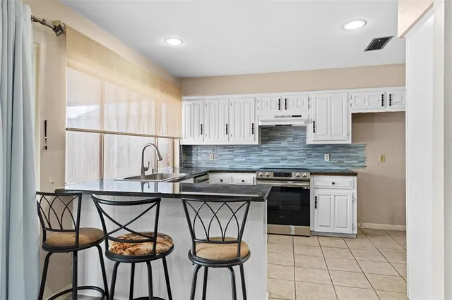 a kitchen with stainless steel appliances granite countertop a stove a sink and a refrigerator