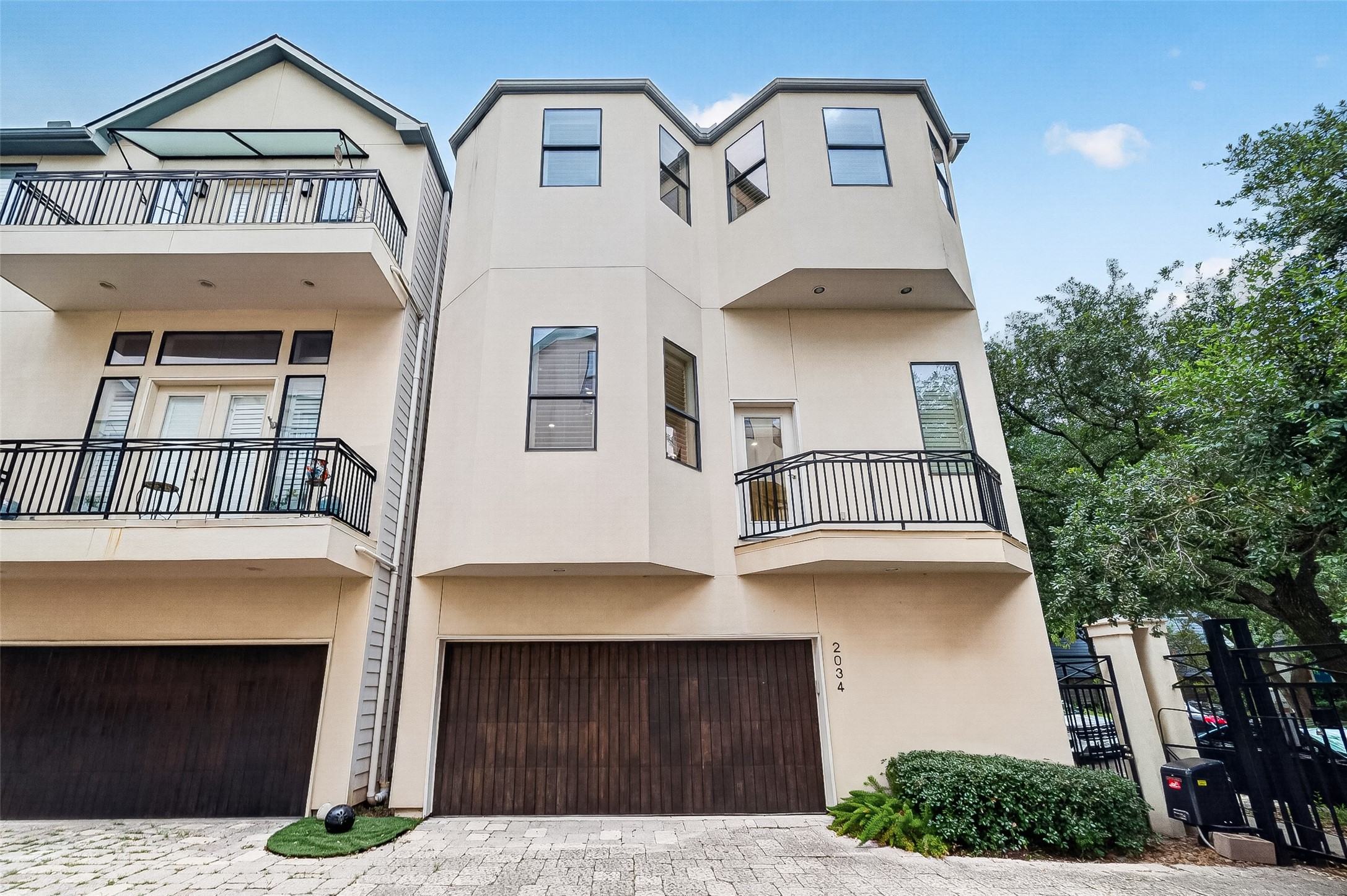 2034 Colquitt Street, Unit A Houston, TX 77098 - Photo 6 of 41 This classic house features a three-story design with a sleek stucco exterior. It includes multiple balconies with black railings and a spacious two-car garage, garage door opener with wooden doors. The property is surrounded by greenery, adding to its curb appeal.