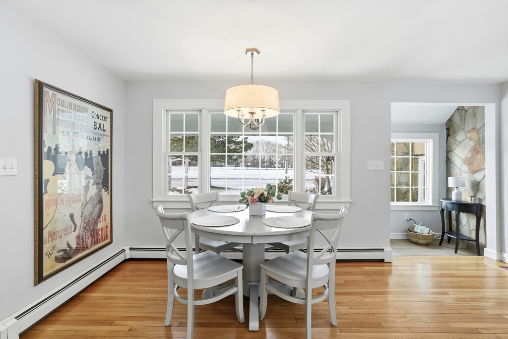 63 Bancroft Road Cohasset, MA 02025 - Photo 11 of 41 a dining room with wooden floor a chandelier a glass table and chairs