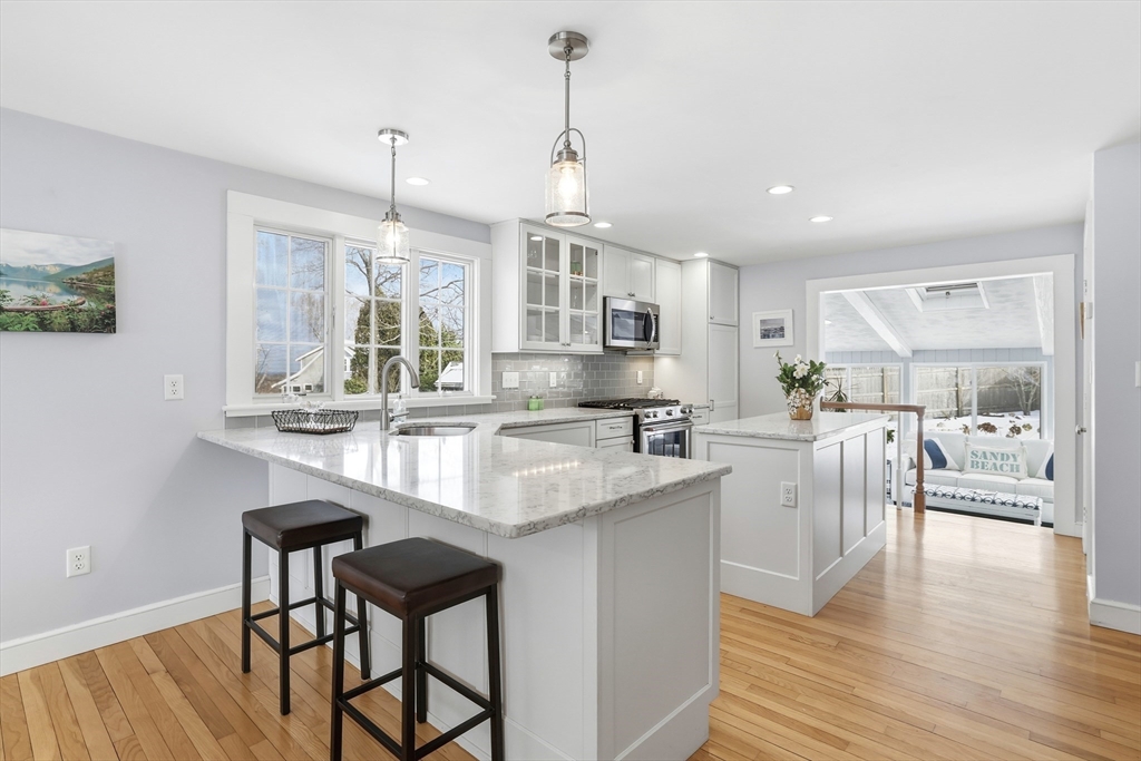 63 Bancroft Road Cohasset, MA 02025 - Photo 4 of 41 a kitchen with stainless steel appliances granite countertop a kitchen island a stove a sink a dining table and chairs