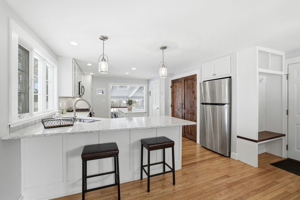 63 Bancroft Road Cohasset, MA 02025 - Photo 6 of 41 a kitchen with stainless steel appliances granite countertop a refrigerator a sink dishwasher a stove and white cabinets with wooden floor