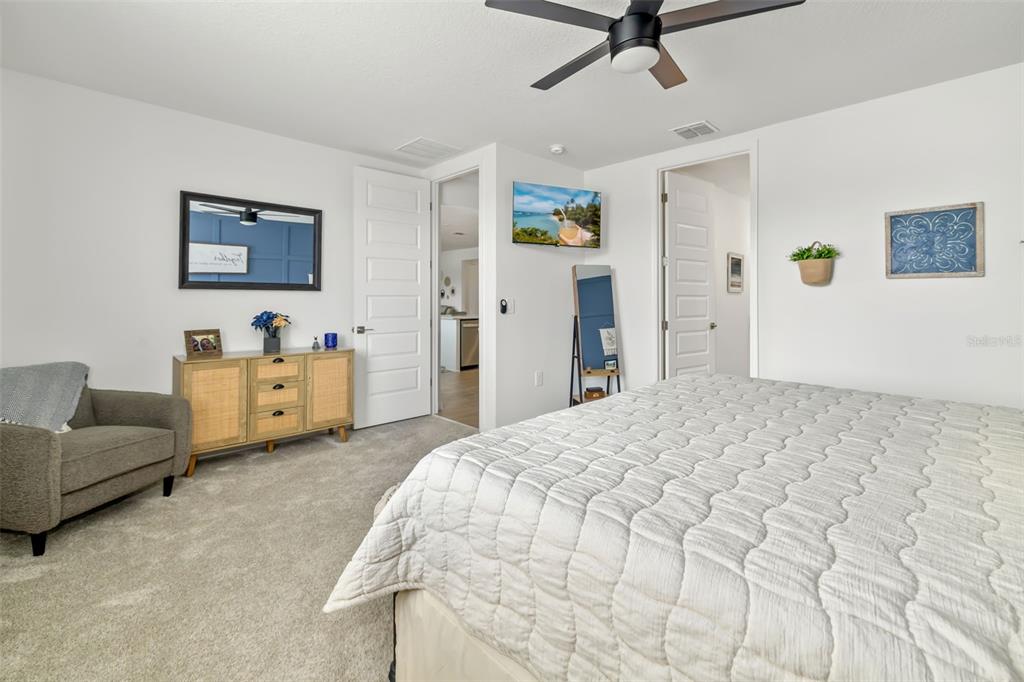 14086 Ginnie Spgs Way Parrish, FL 34219 - Photo 13 of 49 a bedroom with a bed and a chandelier