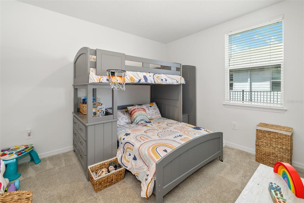 14086 Ginnie Spgs Way Parrish, FL 34219 - Photo 16 of 49 a bed sitting in a bedroom next to a window