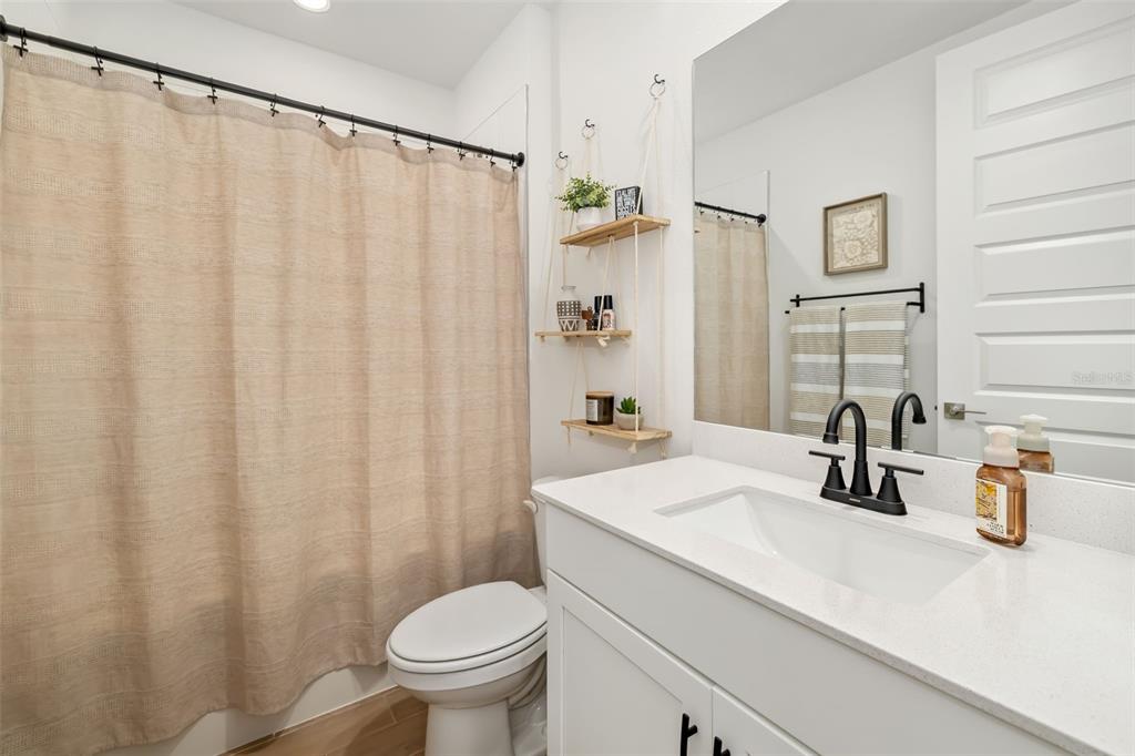 14086 Ginnie Spgs Way Parrish, FL 34219 - Photo 18 of 49 a bathroom with a sink a toilet and shower curtain