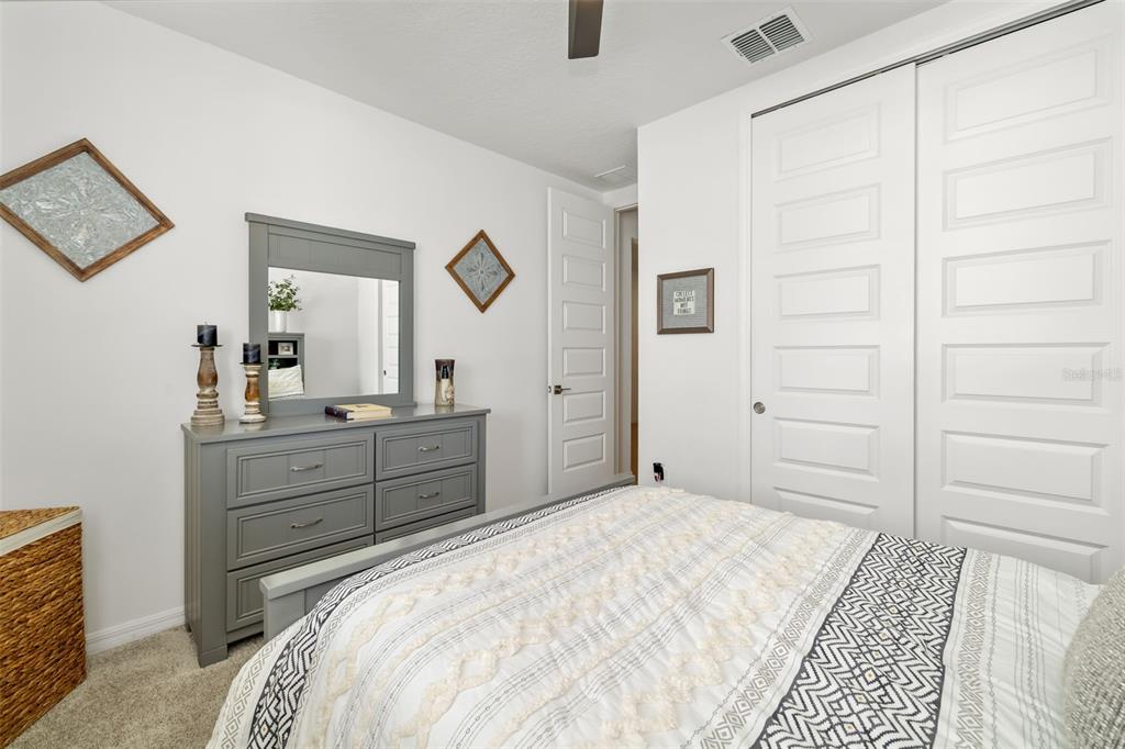 14086 Ginnie Spgs Way Parrish, FL 34219 - Photo 20 of 49 a bedroom with a bed and a dresser