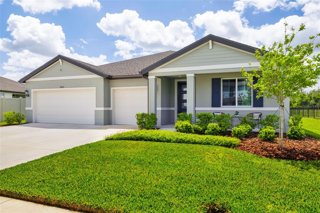 14086 Ginnie Spgs Way Parrish, FL 34219 - Photo 2 of 49 a front view of a house with a garden and plants