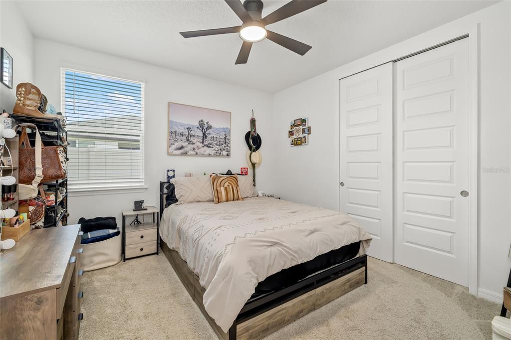 14086 Ginnie Spgs Way Parrish, FL 34219 - Photo 22 of 49 a bedroom with a bed and a chandelier