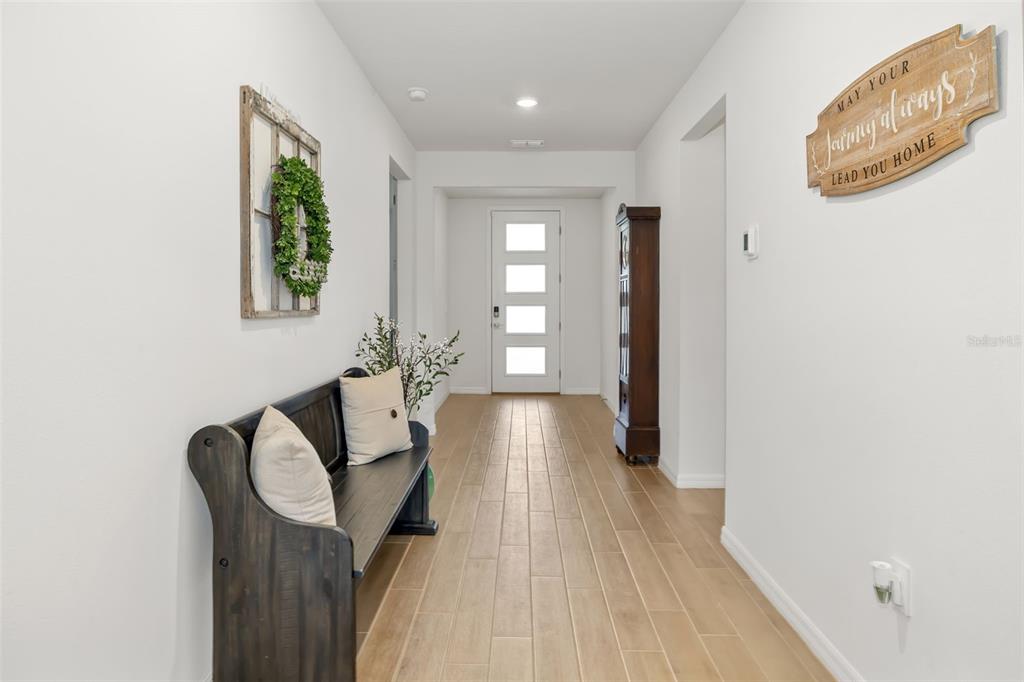 14086 Ginnie Spgs Way Parrish, FL 34219 - Photo 10 of 49 a view of a hallway with wooden floor and furniture