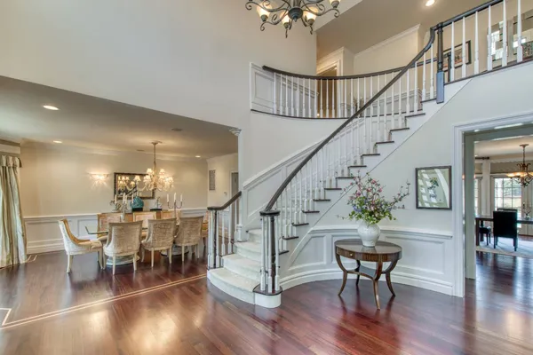 a view of a dining room with furniture a chandelier and wooden floor