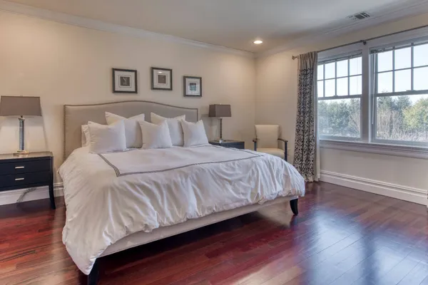 a large bed sitting in a bedroom next to a window