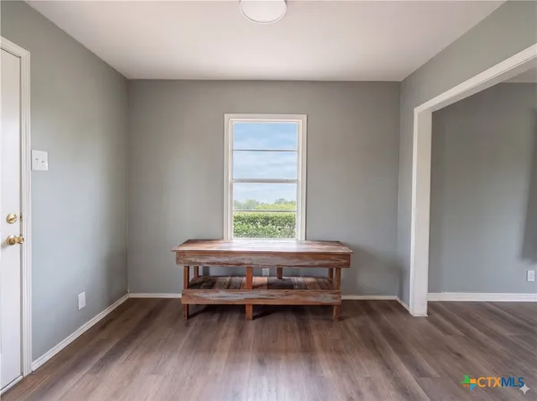 a living room with a wooden floor and a window
