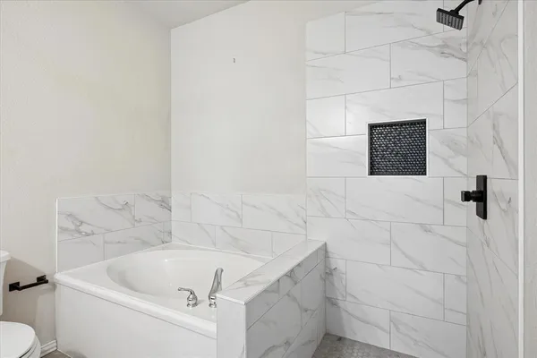 a bathroom with a tub and toilet