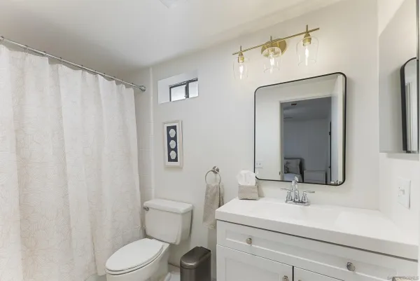 a bathroom with a toilet a sink and a mirror