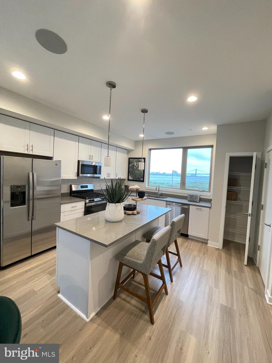 3125 Beachview Lane Philadelphia, PA 19125 - Photo 10 of 37 a kitchen with stainless steel appliances kitchen island granite countertop a table chairs refrigerator and microwave