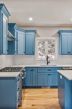 a kitchen with stainless steel appliances granite countertop a sink stove and cabinets