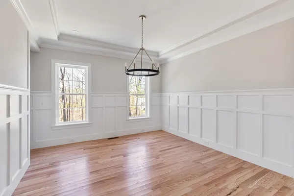 a view of a room with wooden floor chandelier and windows
