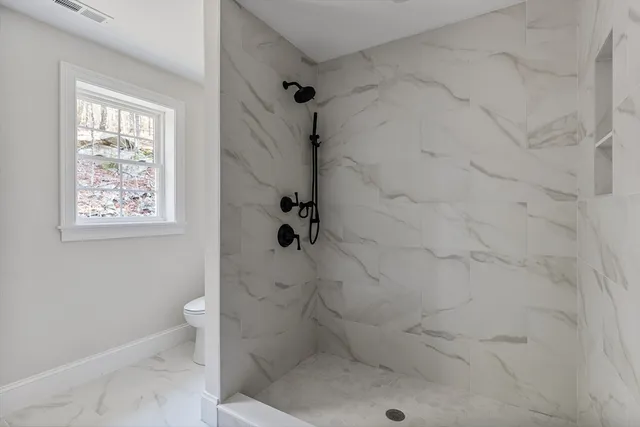 a bathroom with a toilet and a shower