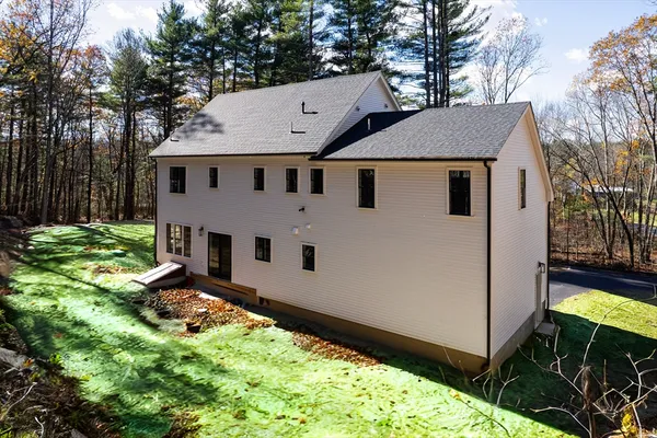 a view of a white house with a big yard and large trees