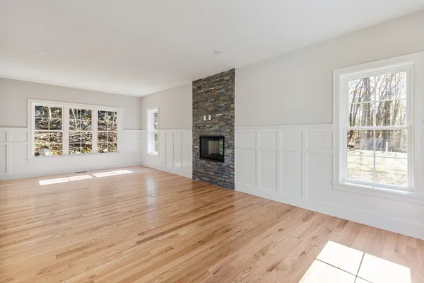 a view of an empty room with a window and wooden floor