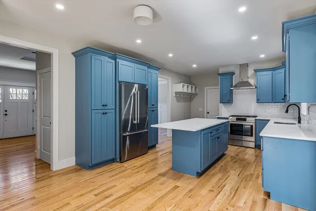 a kitchen with stainless steel appliances granite countertop a refrigerator stove and wooden cabinets