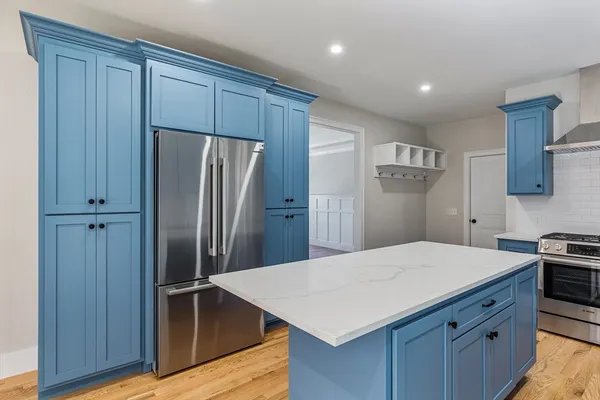 a kitchen with a refrigerator a sink and wooden cabinets